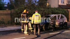 Police & Firefighters by burned car in Acton, London