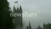 Desite heavy rain the crowds remain watching the Jubilee Flotilla in the shadow of Big Ben