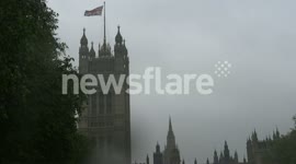 Desite heavy rain the crowds remain watching the Jubilee Flotilla in the shadow of Big Ben