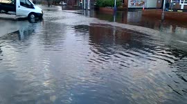 white flat bed truck drives through flood in Egham