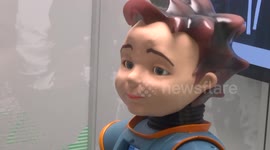 Cute robot child communicates with visitors at exhibition
