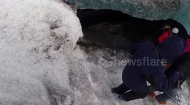 Tourists explore ice cave under glacier in Iceland