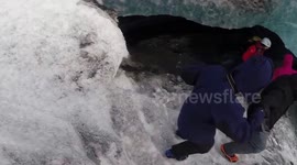 Tourists explore ice cave under glacier in Iceland