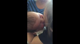 Adorable baby 'feeds' off sister's cheek