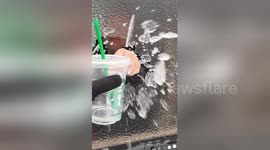 Woman punches through ice sheet to grab drink from car