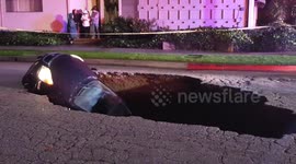 Sinkhole swallows two cars with driver still inside.