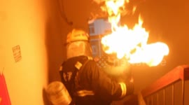 Brave firefighter carries flaming gas cylinder out of building