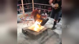 Newsflare Edit - Professional wrestler CHOKESLAMS opponent onto FLAMING board onto of CINDERBLOCKS!