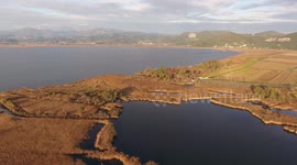 Aerial shot, fall landscape in Italy, flying above fields and a huge lake, filmed with drone, 4K