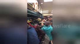 Shoppers fight for reduced price produce at Tesco supermarket