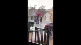 'Hero' holds umbrella over elderly man's head during hail storm