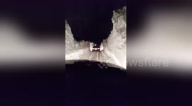Motorists drive between snow banks after blizzard in Canada