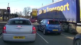 Lorry rear door almost hits car stopped at traffic light