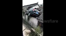 Out-of-control car crashes onto house roof