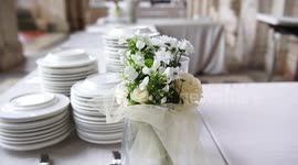 Wedding dinner preparation, beautiful flowers and white plates, selective focus, 4K