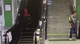 Woman leaving belongs on tube runs the wrong way down escalator