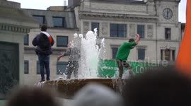 Three guys jump up the fountain at the London’s St Patrick’s Day 2017 in Trafalgar Square
