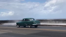 Man luckily avoids waves by Havana's Malecon