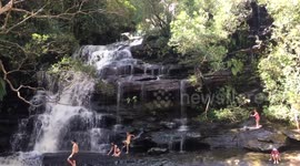 Australian children playing in waterfall after heavy rains
