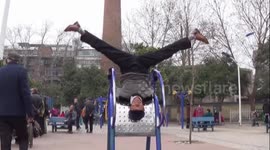 Elderly fitness master shows off skills on public fitness equipment