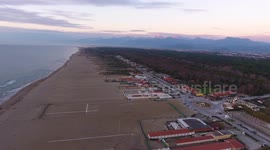 Aerial shot, incredibly beautiful calm sea in Italy in the sunset light with lots of clouds, filmed with drone, 4K