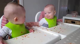 Twin babies enjoy 'chatting' over a meal