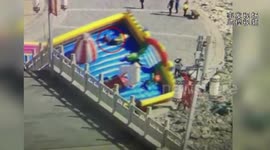 Chinese children are thrown out when wind turns over inflatable bouncer