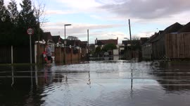 Wakeboarder rides down a flooded road, with traffic