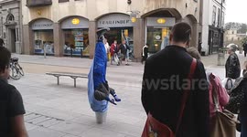 Man upside down with his head in a bucket! Street entertainer!