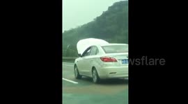 Car with open bonnet spotted driving on Chinese motorway