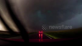 Powerful tornado crosses road in front of storm chaser's car
