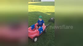 Father and uncle use RC truck to pull child in wagon