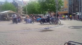 Motorcycle knocks table (and diner) flying as it hurtles through market