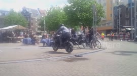 Motorbike races through Amsterdam market
