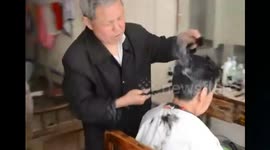 Chinese barber straightens hair with hot tongs