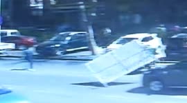 Metal board blown down by strong wind hits vehicle