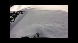 Snowboarder narrowly avoids being swept off by avalanche