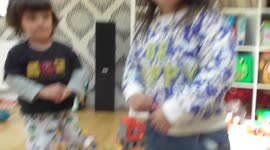 Toddler kicks dominoes over & gets tickled