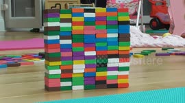 Toddler kicks big stack of dominoes