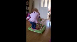 Toddler hitches a ride on baby in walker