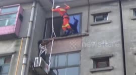 Firefighters rescue an elderly woman trapped on a window ledge