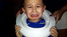 Boy gets toilet seat stuck on head