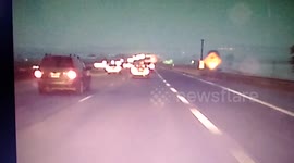 Tire narrowly misses hitting car on highway.