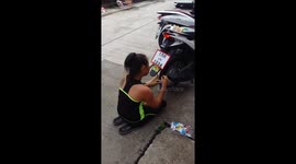 Thai woman blows up party balloons using motorbike exhaust