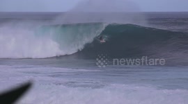 Surfer rides huge wave in Hawaii