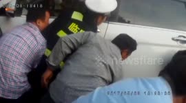 Passersby help lift a car up to release a man trapped under it