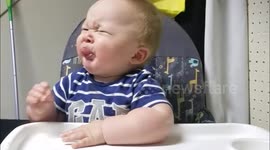 Cute baby tries eating a lemon