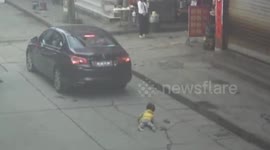 Toddler luckily escapes being run over by car
