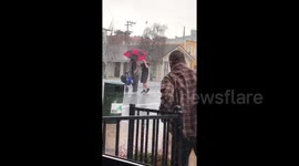 Newsflare Edit - 'Hero' holds umbrella over elderly man's head during hail storm