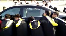 Students carry car out of the way for graduation picture